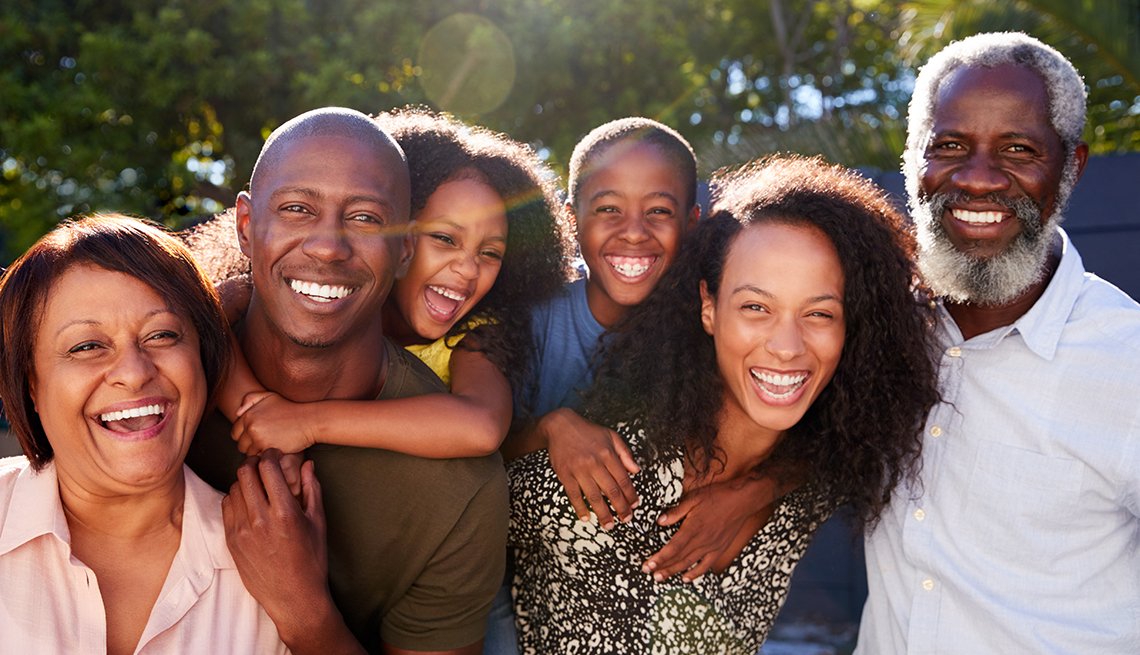 Outdoor Portrait Of Multi-Generation Family In Garden At Home Against Flaring Sun